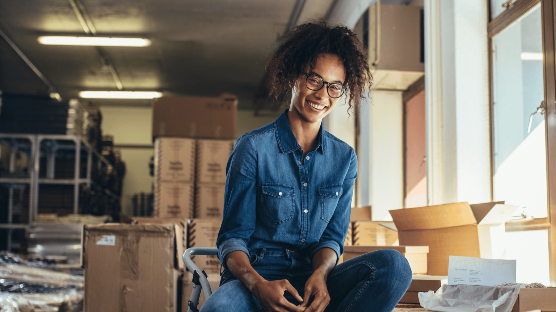 A small business owner smiling in the operations space of her shop