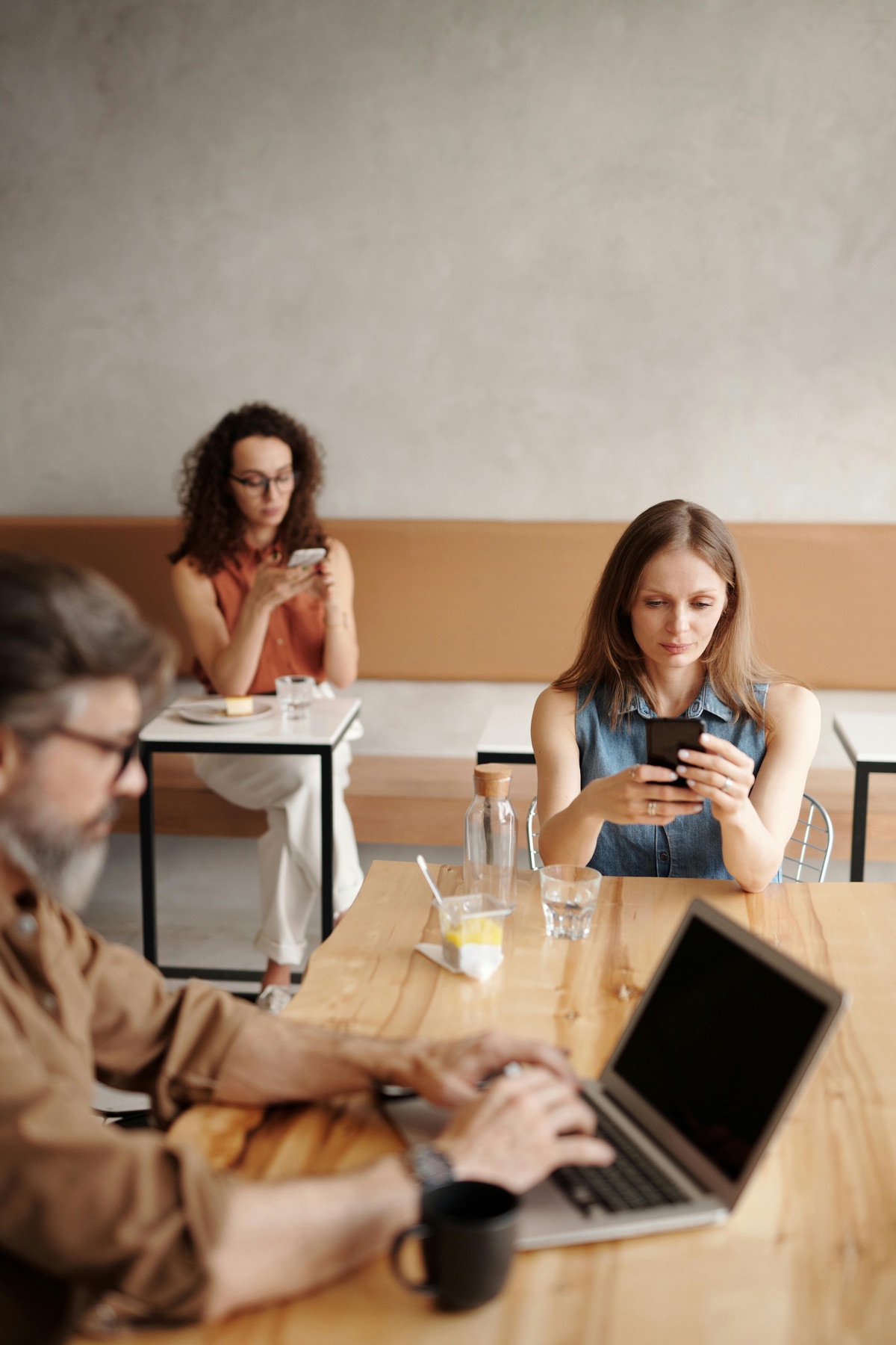 An agency team working from a café table on phones and a laptop