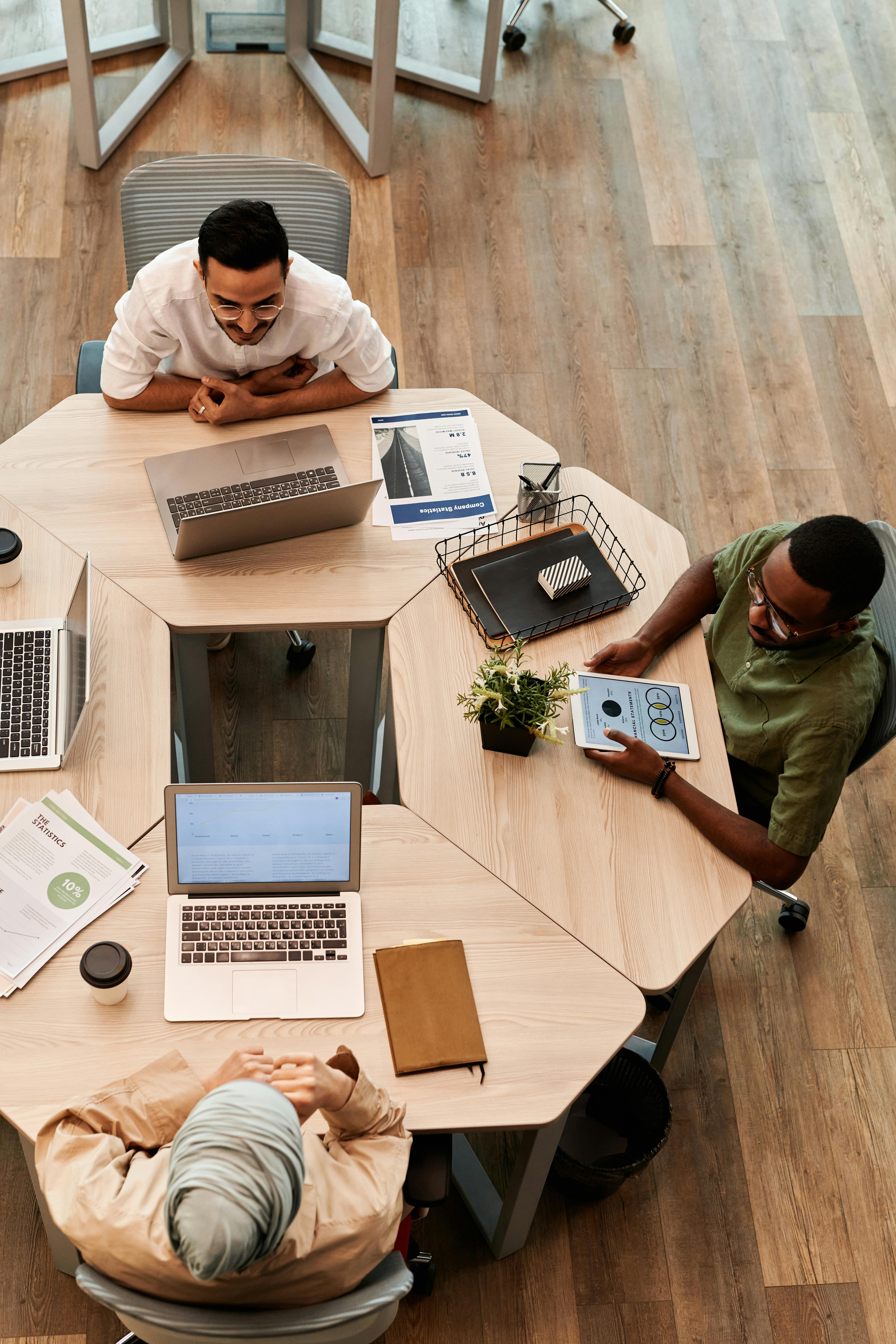 Overhead view of a small team gathered around a table working through a quarterly review